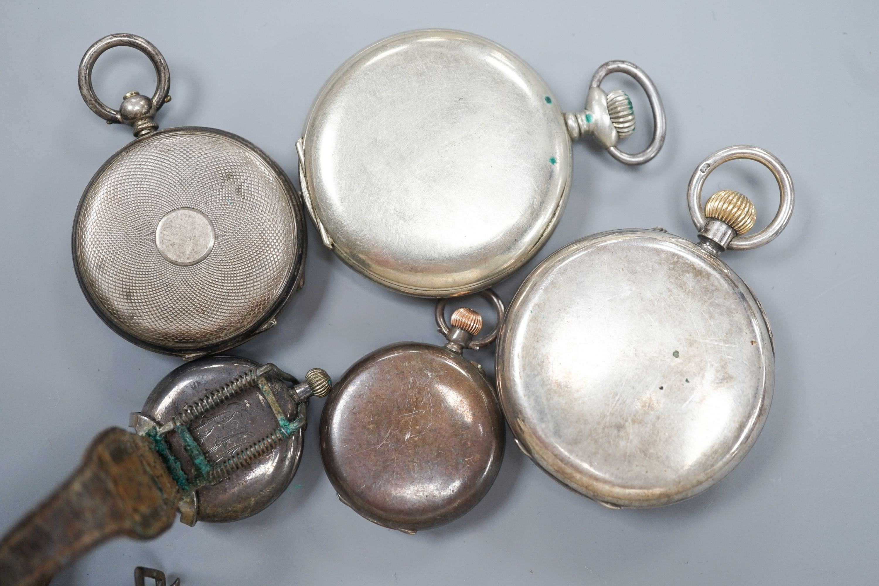An early 20th century silver open face pocket watch, two white metal fob watches, a white metal wrist watch and one other pocket watch.